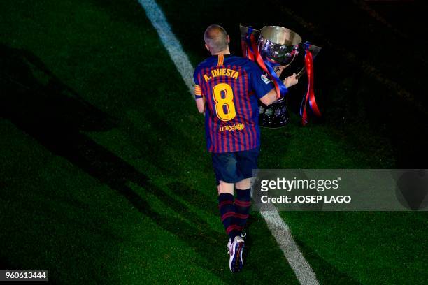 Barcelona's Spanish midfielder Andres Iniesta holds the Liga trophy during a tribute at the end of the Spanish league football match between FC...