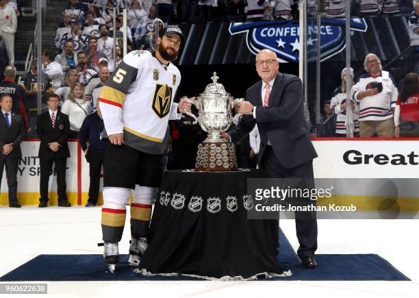 Deryk Engelland of the Vegas Golden Knights and NHL Deputy Commissioner Bill Daly pose with the Clarence S. Campbell Trophy following a 2-1 victory...