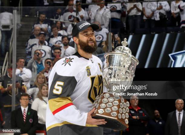 Deryk Engelland of the Vegas Golden Knights carries the Clarence S. Campbell Trophy off the ice following a 2-1 victory over the Winnipeg Jets in...