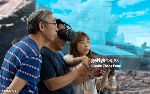 People try on VR glasses on the 2nd World Intelligence Congress, which was held in Tianjin Meijiang Exhibition Center from May 16-18, 2018.