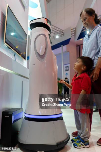 People are communicating with robots on the 2nd World Intelligence Congress, which was held in Tianjin Meijiang Exhibition Center from May 16-18,...