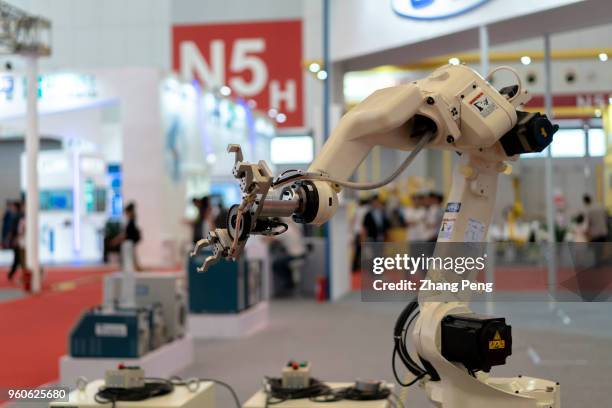 An industrial robot shows its skills on the 2nd World Intelligence Congress, which was held in Tianjin Meijiang Exhibition Center from May 16-18,...