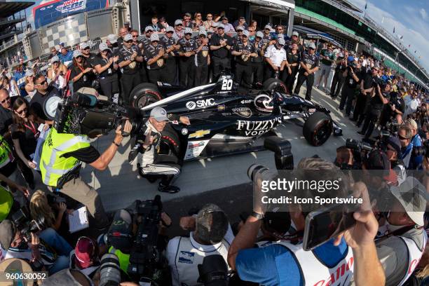 Ed Carpenter, driver of the Ed Carpenter Racing Chevrolet, places the P1 sticker on his car and poses for photos after recording the fastest time to...