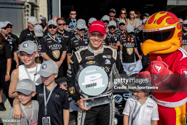 Ed Carpenter, driver of the Ed Carpenter Racing Chevrolet, holds a Verizon P1 award and poses for photos with his children after recording the...