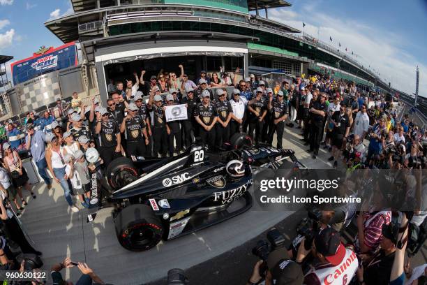 Ed Carpenter, driver of the Ed Carpenter Racing Chevrolet, holds a P1 banner and poses for photos with his crew and family after recording the...