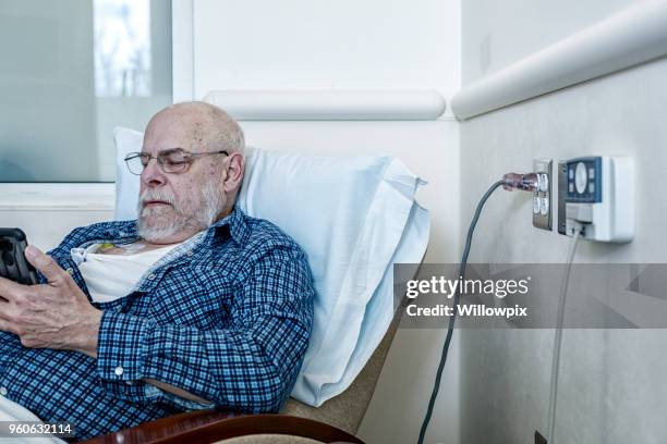 cancer chemotherapy patient reading smart phone - port males chemo stock pictures, royalty-free photos & images