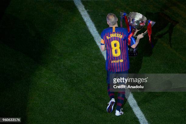 Barcelona's midfielder Andres Iniesta holds a Spanish league throphy at the end of the Spanish league football match between FC Barcelona and Real...