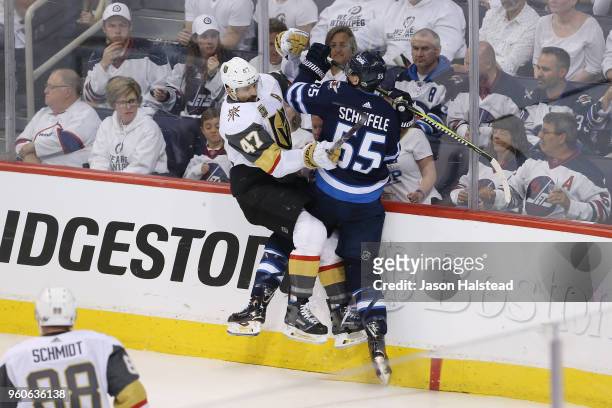 Luca Sbisa of the Vegas Golden Knights and Mark Scheifele of the Winnipeg Jets collide along the boards during the second period in Game Five of the...