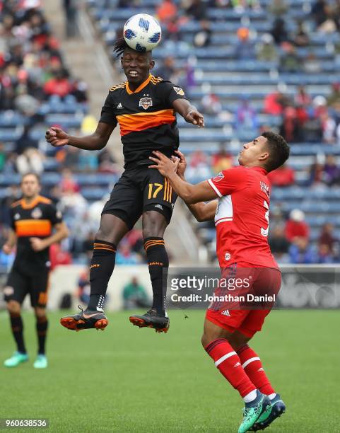 Alberth Elis of the Houston Dynamo leaps to head the ball over Brandon Vincent of the Chicago Fire at Toyota Park on May 20, 2018 in Bridgeview,...