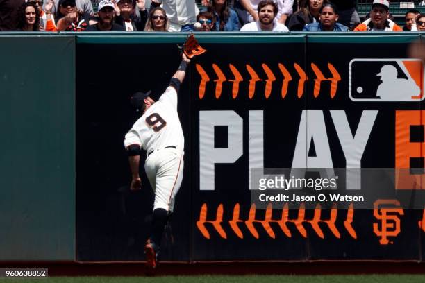 Brandon Belt of the San Francisco Giants reaches for but is unable to catch a fly ball hit for a double by Pat Valaika of the Colorado Rockies during...