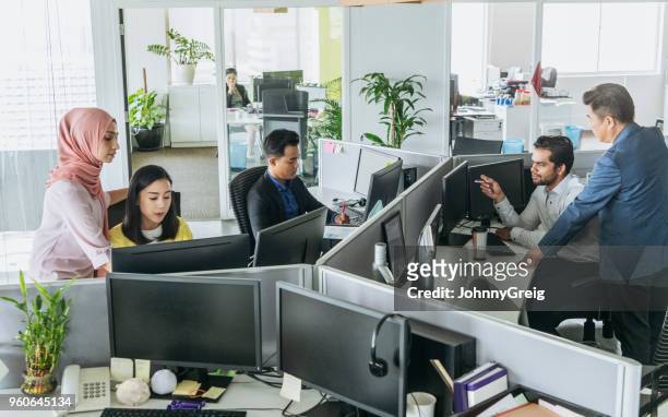busy office with men and women working at desks - cubicles imagens e fotografias de stock