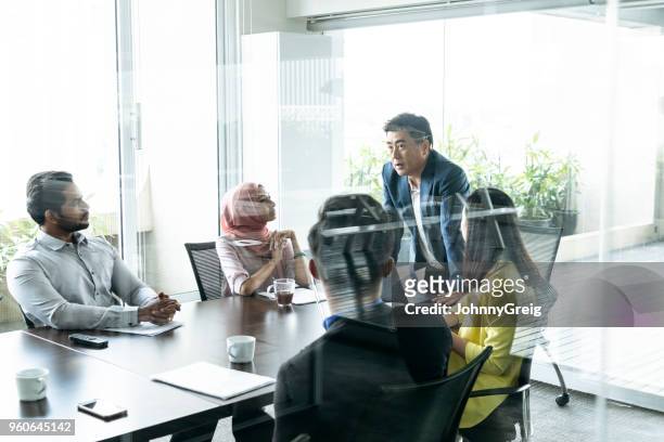 business meeting in modern office view through glass - 50 year old indian lady stock pictures, royalty-free photos & images