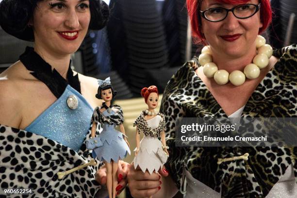 Two women, impersonating Betty Rubble and Wilma Flinstone of the American animated sitcom 'The Flinstones', show their favorite dolls as they attend...