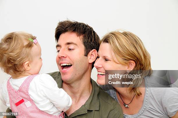 happy young family of three smiling father mother toddler - wepix stock pictures, royalty-free photos & images