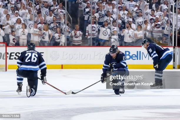 Blake Wheeler, Patrik Laine and Bryan Little of the Winnipeg Jets react following the final buzzer in a 2-1 loss against the Vegas Golden Knights in...