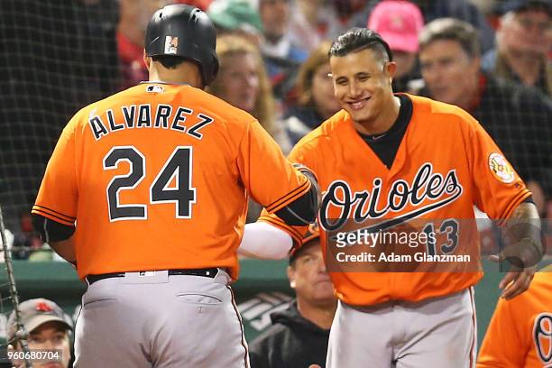 Pedro Alvarez high fives Manny Machado of the Baltimore Orioles after hitting a two-run home run in the sixth inning of a game against the Boston Red...