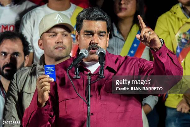Venezuelan President Nicolas Maduro holds the political constitution after the National Electoral Council announced the results of the voting on...