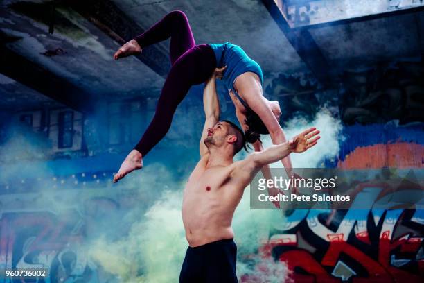 couple practising acroyoga on outdoor stage - graffiti hintergrund stock pictures, royalty-free photos & images