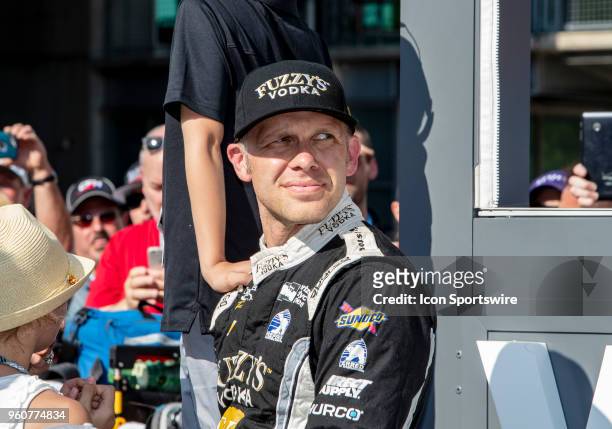 Ed Carpenter, driver of the Ed Carpenter Racing Fuzzy's Vodka Chevrolet, looks at the monitors while currently holds the number 1 position during...