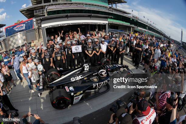 Ed Carpenter, driver of the Ed Carpenter Racing Chevrolet, holds a P1 banner and poses for photos with his crew and family after recording the...