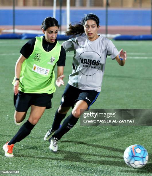 Seven team player Amna al-Farhan vies for the ball against Vamos team player Reem al-Mulla during the third edition of Kuwait's Women Football...