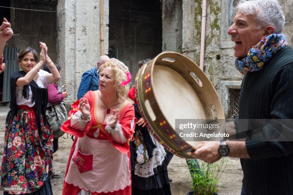 Man Playing a Drumer and Singing in a street of Naples, Italy