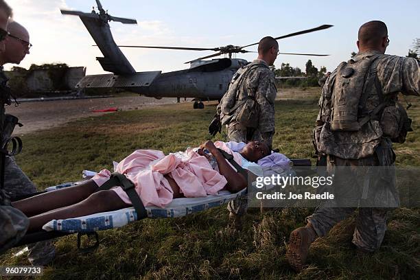 Army soldiers from the 82nd Airborne carry an injured women to an awaiting Navy helicopter as they medivac her after she was injured during the...