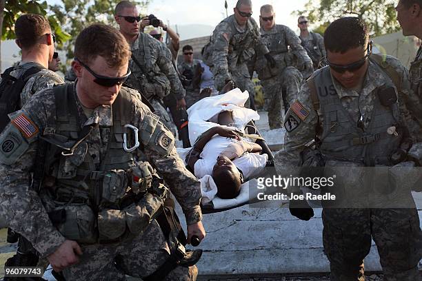 Army soldiers from the 82nd Airborne carry an injured man to an awaiting Navy helicopter as they medivac him after he was injured during the...