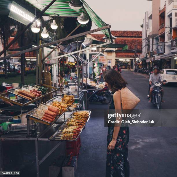 woman walking on night market in vietnam - vietnam market stock pictures, royalty-free photos & images