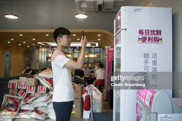 Customer scans a quick respond code using a smartphone to purchase products from a Mr. Fresh unmanned kiosk inside the offices of its affiliate Miss...