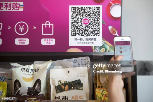 Customer scans a quick respond code using a smartphone to purchase products from a Mr. Fresh unmanned kiosk inside the offices of its affiliate Miss...