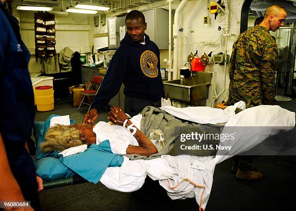 Year-old Haitian woman is comforted by her son aboard the amphibious assault ship USS Bataan before being transported to the Military Sealift Command...