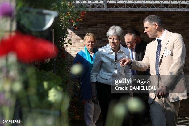 Britain's Prime Minister Theresa May is shown around the Lemon Tree Trust Garden designed by Tom Massey, inspired by the resilience, determination...