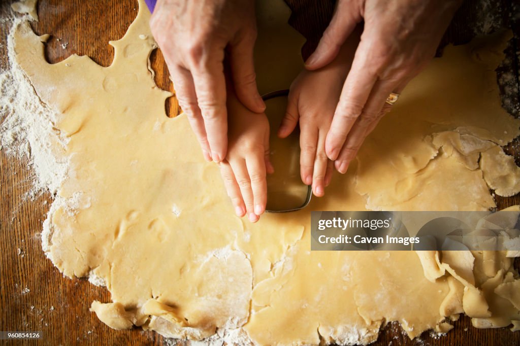 Cropped image of hands cutting pastry dough
