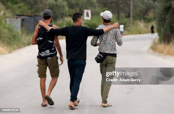 Refugees walk together outside the Moria refugee camp on May 20, 2018 in Mytilene, Greece. Despite being built to hold only 2,500 people, the camp on...