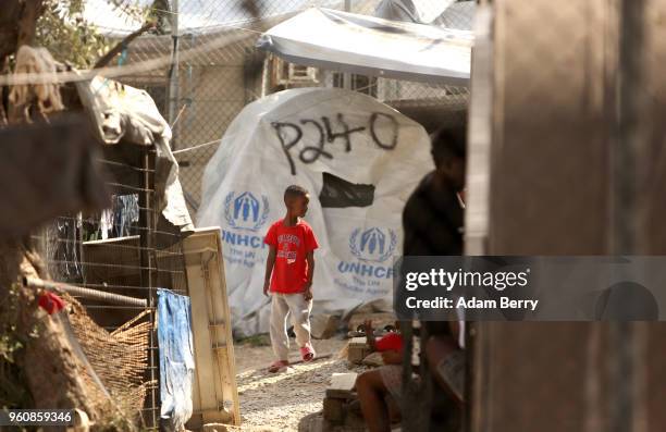 An African refugee child walks through the Moria refugee camp on May 20, 2018 in Mytilene, Greece. Despite being built to hold only 2,500 people, the...