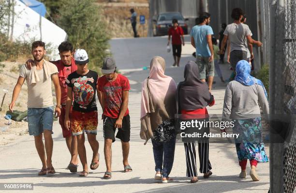 Refugees walk through the Moria refugee camp on May 20, 2018 in Mytilene, Greece. Despite being built to hold only 2,500 people, the camp on the...