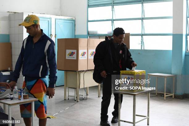 Voter seen cast his ballot while an other registering at a polling station. The presidential elections called by the National Constituent Assembly...