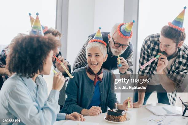 mature business woman celebrating birthday at office - senior woman birthday stock pictures, royalty-free photos & images