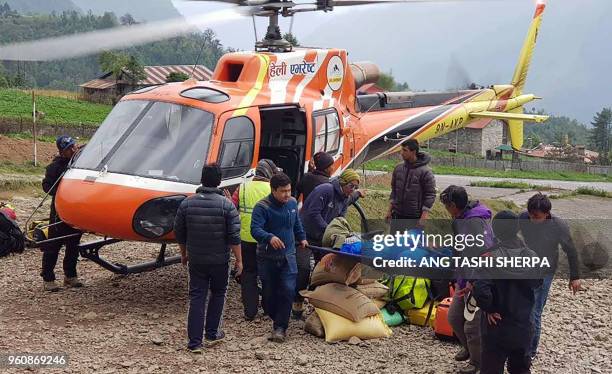 Nepali men carry the body of Japanese climber Nobukazu Kuriki onto a helicopter after it was recovered from Mount Everest, at a helipad in Lukla to...