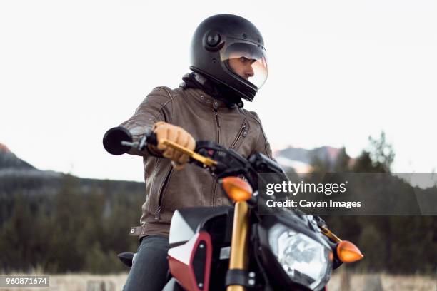 man on motorcycle against clear sky - motorcycle handle stock pictures, royalty-free photos & images