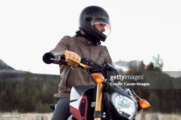 man on motorcycle against clear sky - bike handle stock pictures, royalty-free photos & images