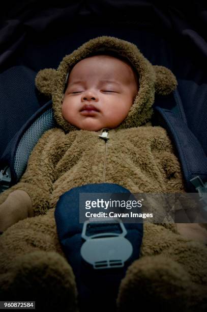 high angle view of toddler in bear suit sleeping in car - cute baby sleeping stock pictures, royalty-free photos & images