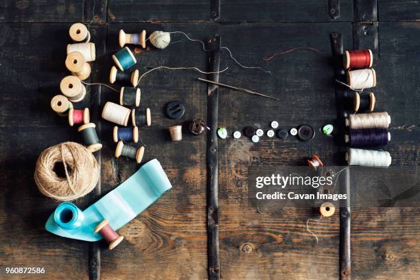 overhead view of sewing equipment with thread reels on wooden table - ribbon sewing item stock pictures, royalty-free photos & images