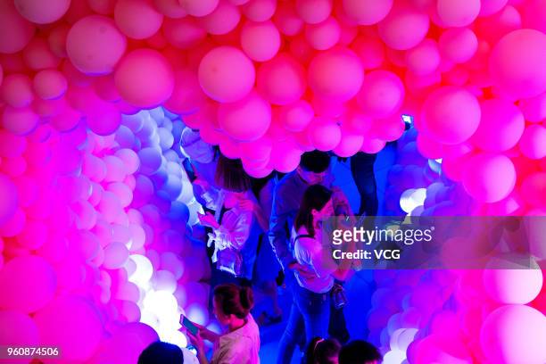 People take photo of the balloons during during the 'Balloon for Love' event on Network Valentine's Day at Joy City on May 20, 2018 in Yantai, China....