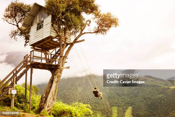 man enjoying on swing against mountain and sky - tree house bildbanksfoton och bilder