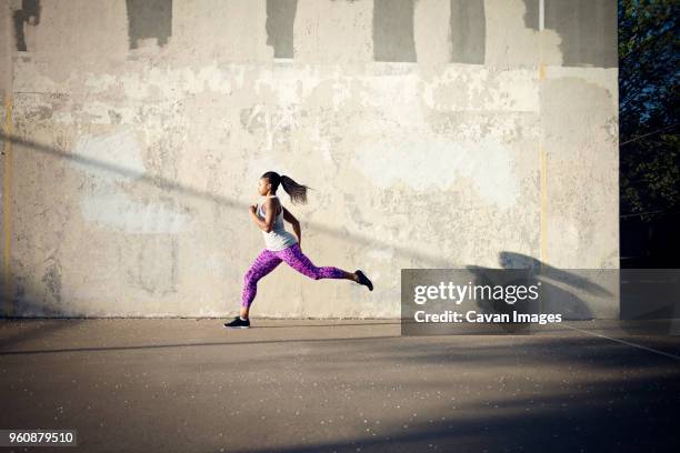 woman jogging on street by wall - one person in focus stock pictures, royalty-free photos & images