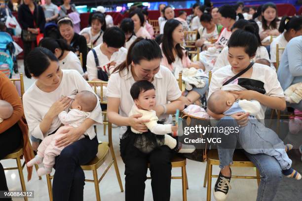 Nearly a hundred young mothers attend a breastfeeding public welfare activity on National breastfeeding promotion day on May 20, 2018 in Xiangyang,...