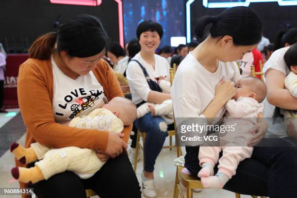 Nearly a hundred young mothers attend a breastfeeding public welfare activity on National breastfeeding promotion day on May 20, 2018 in Xiangyang,...