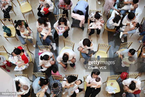 Nearly a hundred young mothers attend a breastfeeding public welfare activity on National breastfeeding promotion day on May 20, 2018 in Xiangyang,...